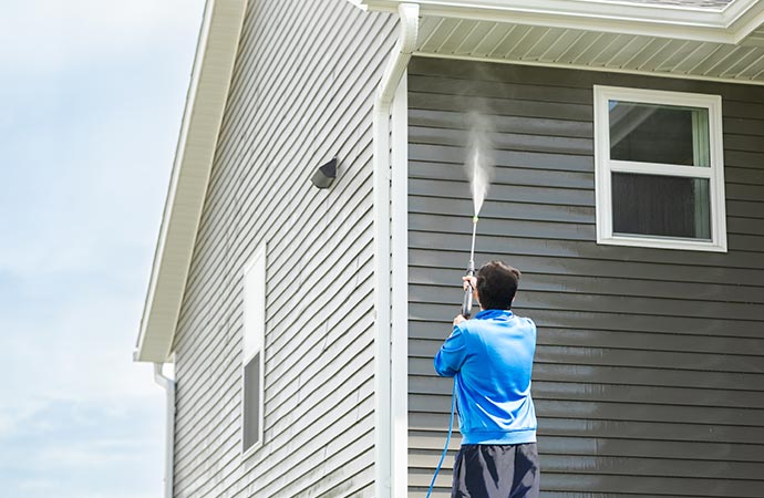 Expert soft-washes a building's exterior for a refreshed look.