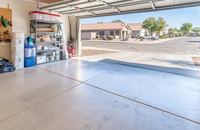 An organized garage with an open door showing a street.