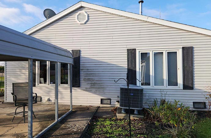 Side-by-side comparison of a house before and after pressure washing