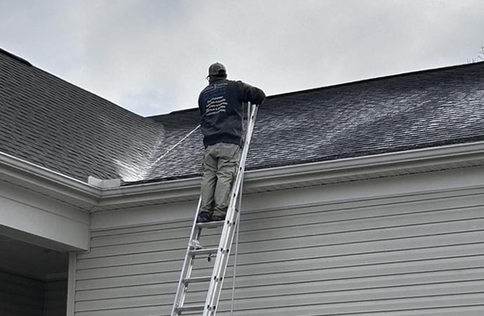 Pressure washer cleaning dirt and grime from a house exterior.