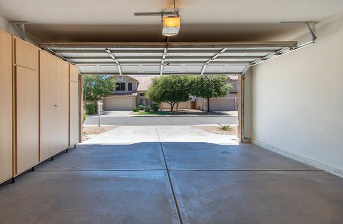 Professional worker pressure washing garage floors