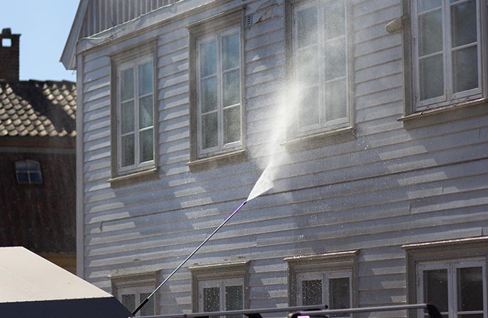 high-pressure washer cleaning house siding