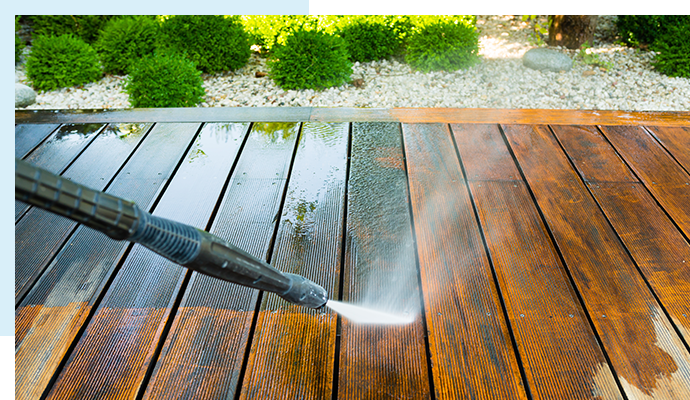 Pressure washing a wooden terrace surface for a clean and revitalized appearance.