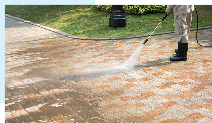 A skilled pressure washer cleaning a building to make it look brand new.