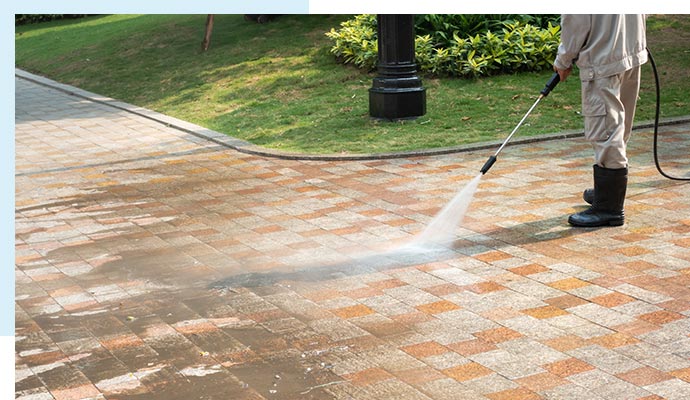 Worker cleaning sidewalk for a tidy and safe pedestrian path.